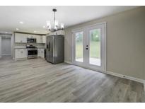 Bright kitchen features stainless steel appliances, white cabinets, and modern light fixtures at 4176 King Edward Dr, Douglasville, GA 30135