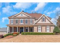 Stately two-story home with a welcoming front porch, manicured lawn, and classic architectural details at 5810 Old Mill Trce, Lithonia, GA 30038