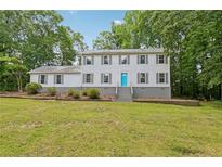 Charming home featuring two stories, a welcoming blue door, and a large, well-maintained front yard at 56 Carlane Cir, Bowdon, GA 30108