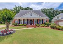 Charming single-story brick home with a columned front porch and a beautifully landscaped front yard at 3468 Aberrone Pl, Buford, GA 30519
