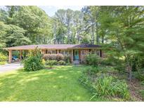 Charming brick ranch home with lush front yard and mature trees creating great curb appeal at 5400 Francis Ave, Stone Mountain, GA 30087