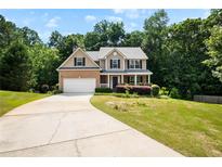 Charming two-story home with brick facade, attached garage, and a well-manicured front yard at 3185 Oak Ridge Ln, Loganville, GA 30052