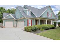 Charming two-story home with a manicured lawn, three car garage and inviting front porch with classic columns at 330 Bay Grove Rd, Loganville, GA 30052