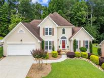 Charming two-story home featuring manicured landscaping and a welcoming red front door at 310 Medridge Dr, Alpharetta, GA 30022
