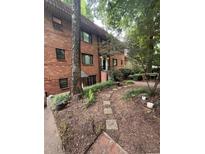 Charming brick exterior of a multi-story condo with landscaped front yard and stepping stone path at 314 3Rd Ne St # 4, Atlanta, GA 30308