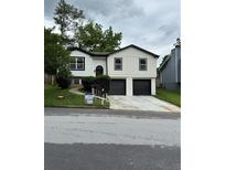 Charming home with a new white siding, black trim, and a two-car garage at 1340 Stoneleigh Way, Stone Mountain, GA 30088