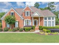 Charming brick home featuring a well-manicured lawn and lush landscaping at 1487 Monarch Ct, Marietta, GA 30062