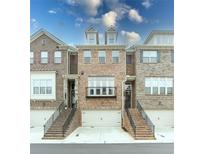 Charming townhome exterior featuring brick facade, balcony, and attached one car garages at 2145 Coventry Dr, Brookhaven, GA 30319