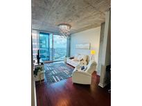Bright living room with floor-to-ceiling windows and comfortable white recliners at 400 W Peachtree Nw St # 3412, Atlanta, GA 30308