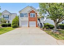 Charming two-story home features a two-car garage, brick accents, and well-manicured landscaping at 1910 Towne Park Dr, Mcdonough, GA 30252
