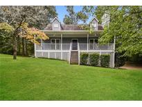 Charming home with a spacious front porch and beautifully maintained lawn, perfect for outdoor enjoyment at 4150 Sterling Pointe Dr, Douglasville, GA 30135