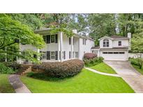 Traditional white two-story home with black shutters, a front porch, and a manicured lawn with mature landscaping at 837 Pine Ridge Dr, Lawrenceville, GA 30043