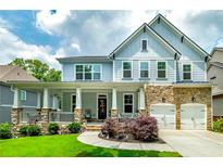 Charming two-story home with stone accents, a well-manicured lawn, and a welcoming covered front porch at 9117 Hanover St, Lithia Springs, GA 30122