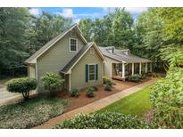 Charming exterior view of a two-story home with a inviting front porch and meticulously landscaped yard at 820 Airline Rd, Mcdonough, GA 30252
