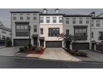 Modern townhome featuring light brick, a one-car garage, and manicured landscaping at 1505 Slopeside Loop, Smyrna, GA 30082