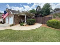 Charming brick home featuring an inviting front yard with a beautiful American flag at 112 Countryside Ct, Woodstock, GA 30189