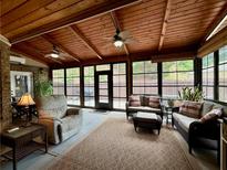 Inviting sunroom with wood ceiling, fan, comfortable seating, and views of the outdoors at 112 Countryside Ct, Woodstock, GA 30189
