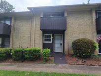 Brick exterior of townhome with small porch, trimmed bushes, and walkway to the front door at 1867 Myrtle Sw Dr # 3, Atlanta, GA 30311
