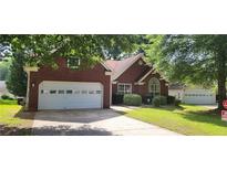 Charming single-story brick home with a well-maintained lawn and attached two-car garage at 2703 Hillvale Cove Dr, Lithonia, GA 30058