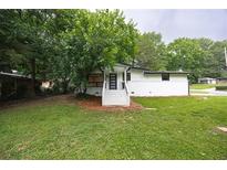Charming home featuring a well-manicured lawn, inviting front entrance, and mature landscaping at 3042 Monterey Dr, Decatur, GA 30032