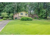 Two-story home featuring a large front lawn and mature trees around the property at 3206 Pyrite Sw Cir, Atlanta, GA 30331