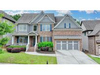 Beautiful two-story brick home featuring a manicured lawn and a two-car garage at 4590 Sierra Creek Dr, Hoschton, GA 30548