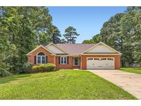 Charming brick home with a well-manicured lawn and attached two car garage at 11473 Summer Creek Dr, Hampton, GA 30228