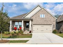 Charming brick home featuring a covered front porch and attached two-car garage at 330 Carriage Glen Ln, Woodstock, GA 30188