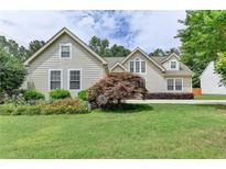 Charming home featuring a well-manicured lawn, beautiful landscaping, and classic siding at 525 Hunnicutt Se Rd, Mableton, GA 30126