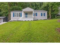 Charming home featuring a well-maintained lawn, blue shutters, and a cozy front porch perfect for enjoying the outdoors at 2222 Beecher Sw Cir, Atlanta, GA 30311
