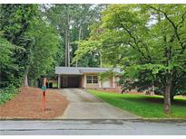 Charming brick home with a well-maintained lawn and a covered carport on a tree-lined street at 2543 Asbury Court Ct, Decatur, GA 30033