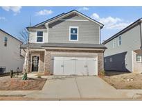 Charming two-story home with a stone-accented facade, a two-car garage, and a well-maintained lawn at 2766 Aralynn Way, College Park, GA 30337