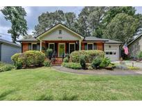 Charming red brick home featuring a lush front yard and well-manicured landscaping at 3232 Valaire Drive Dr, Decatur, GA 30033