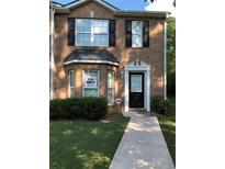 Traditional brick home featuring well-maintained landscaping and a welcoming entrance at 8430 Carlington Ln, Jonesboro, GA 30236