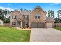 Charming two-story brick home with a three-car garage and well-manicured lawn at 109 Jodi Pl, Locust Grove, GA 30248