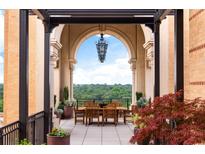 Inviting outdoor patio featuring a dining table, elegant chandelier and beautiful views of the surrounding landscape at 3286 Northside Nw Pkwy # Ph2, Atlanta, GA 30327