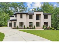 Elegant modern home with a painted brick facade, manicured lawn, and a circular driveway at 4125 Ashwoody Ne Trl, Brookhaven, GA 30319