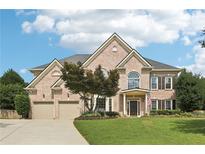 Charming two-story brick home with a well-manicured lawn, two-car garage, and inviting front entrance at 4620 Springdale Ct, Cumming, GA 30041
