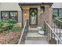 Charming front entrance with brick accents, concrete stairs, and well-maintained landscaping at 2 Arpege Nw Way, Atlanta, GA 30327