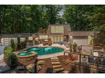 Stunning backyard with pool, spa, deck, and lush greenery for ultimate relaxation and entertainment at 4850 Lake Fjord Pass, Marietta, GA 30068