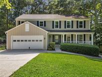 Charming two-story home with black shutters, covered porch and a well-manicured lawn at 1438 Heritage Glen Dr, Marietta, GA 30068