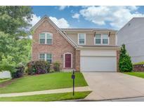 Charming two-story home with a brick facade, manicured lawn, and a two-car garage at 1727 Shire Village Dr, Sugar Hill, GA 30518
