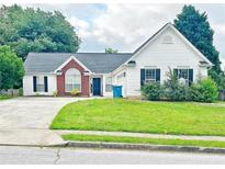 Charming single-Gathering home with a well-manicured lawn, attached garage and a classic brick and vinyl facade at 2647 Midler Ct, Buford, GA 30519