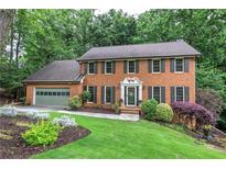 Charming two-story brick home with a well-manicured lawn and mature trees at 425 Bellflower Ct, Roswell, GA 30076