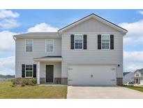 Two-story home with a large garage, light gray siding and black shutters at 600 Tudor St, Kingston, GA 30145
