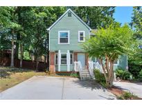 Charming two-story home with green siding, brick accents, and a welcoming front porch staircase at 5037 Laurel Springs Se Way, Smyrna, GA 30082