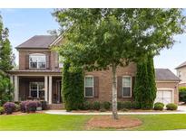 Charming brick home featuring manicured lawn and meticulously maintained landscaping at 5830 Caveat Ct, Suwanee, GA 30024