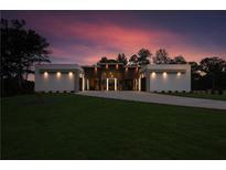 Modern home featuring unique lighting, a sprawling lawn, and a lengthy driveway at sunset at 292 Highway 279, Fayetteville, GA 30214