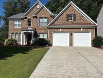 Beautiful two-story brick home with a well-maintained lawn and two-car garage at 5669 Avonley Creek Dr, Sugar Hill, GA 30518