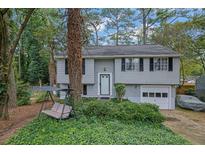Charming home featuring a well-kept lawn, classic siding, and an attached garage, perfect for suburban living at 1377 Tucker Woods Dr, Norcross, GA 30093